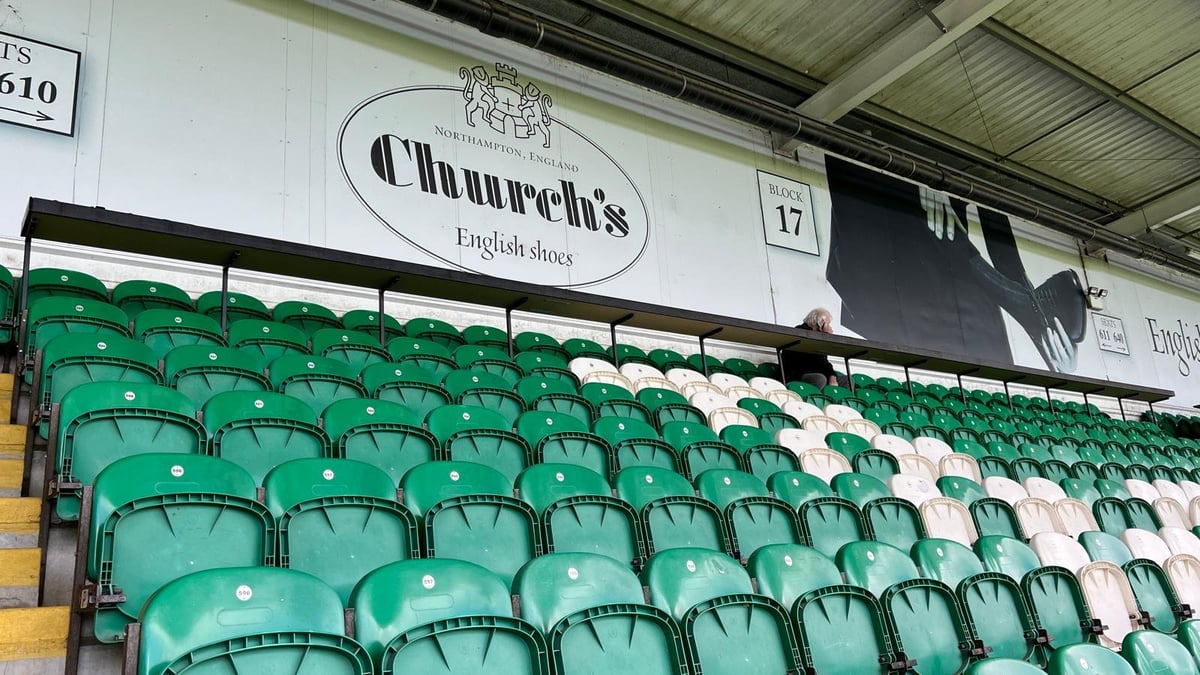 Empty green stadium seats with Celtic FC signage visible on the wall above